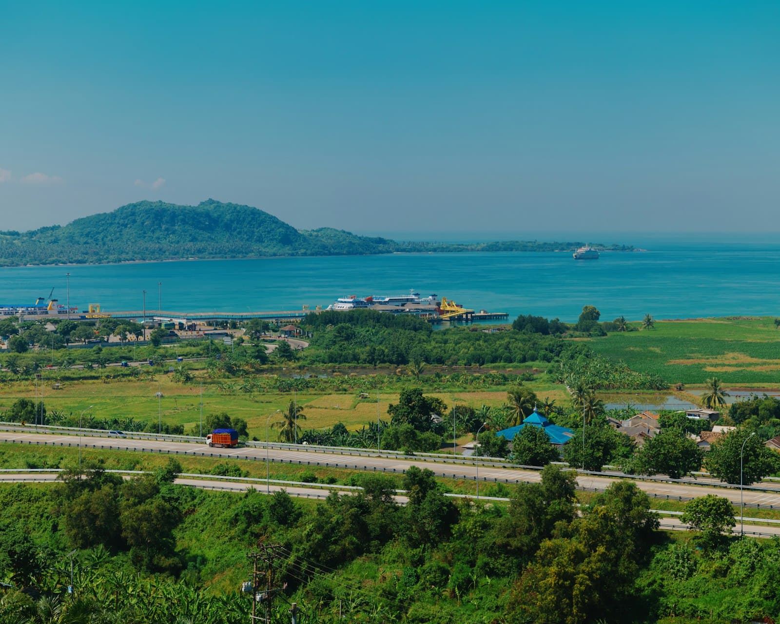 A coastal town with a distant island under a blue sky