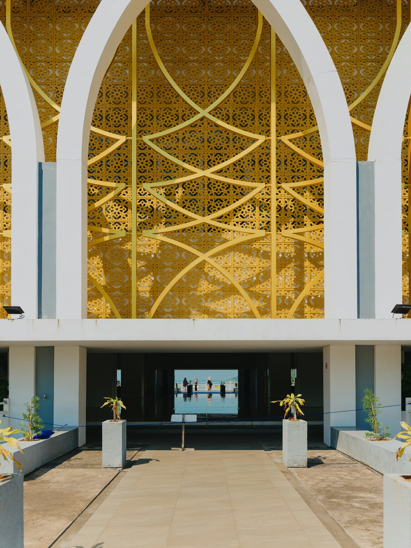 A modern building facade with an ornate golden screen