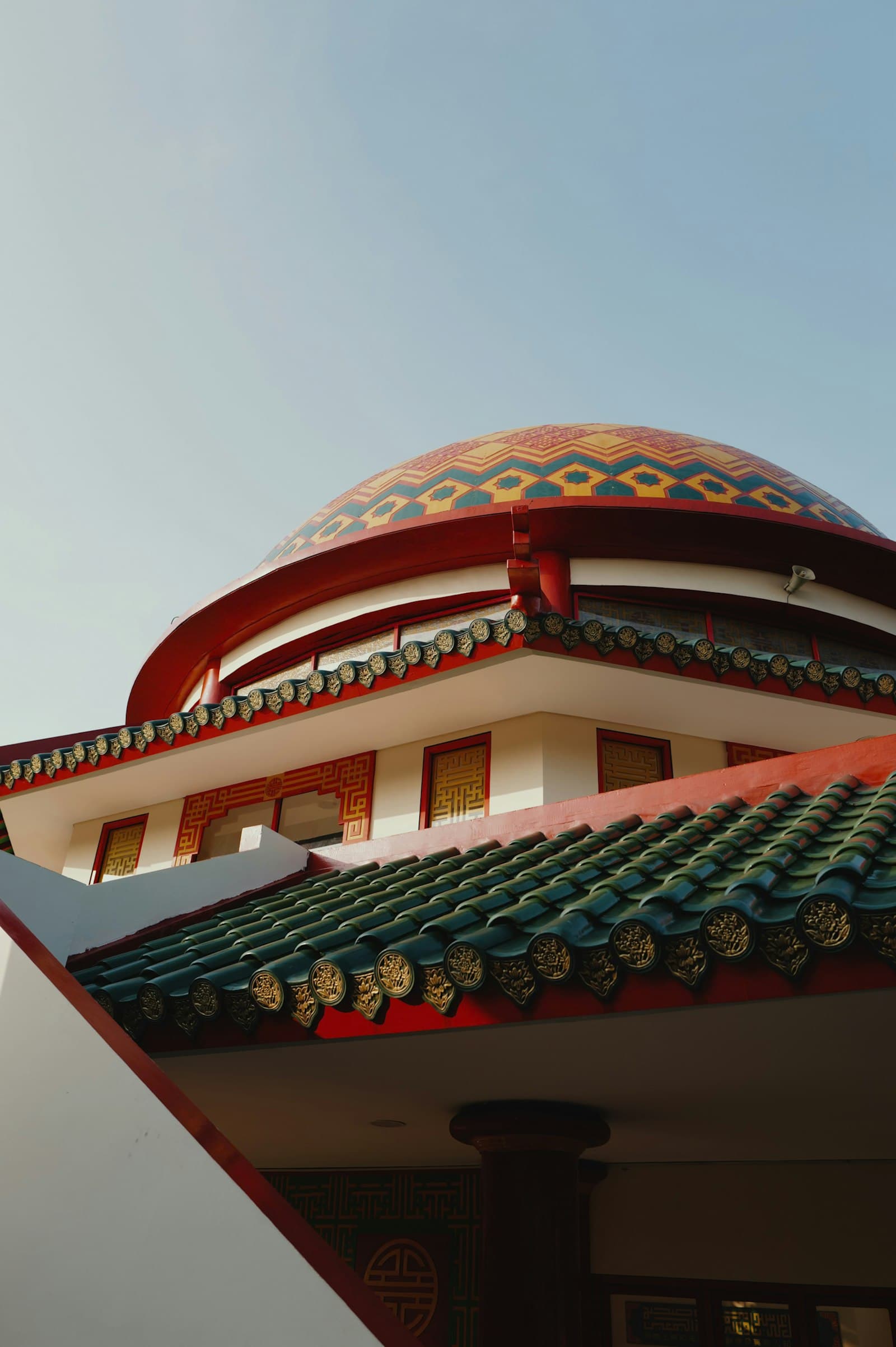 A mosque's dome and roof rising against an open sky