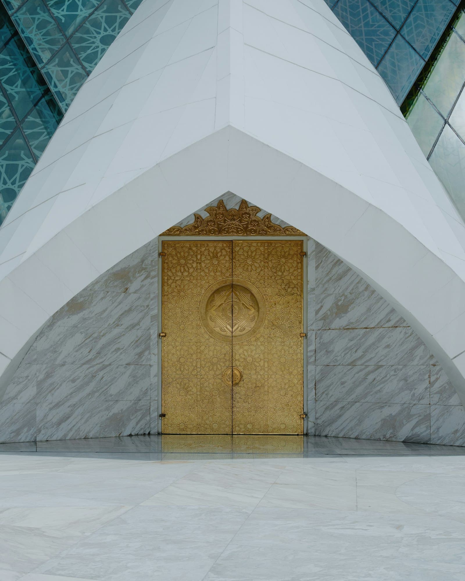 Ornate golden doors set within a modern architectural facade