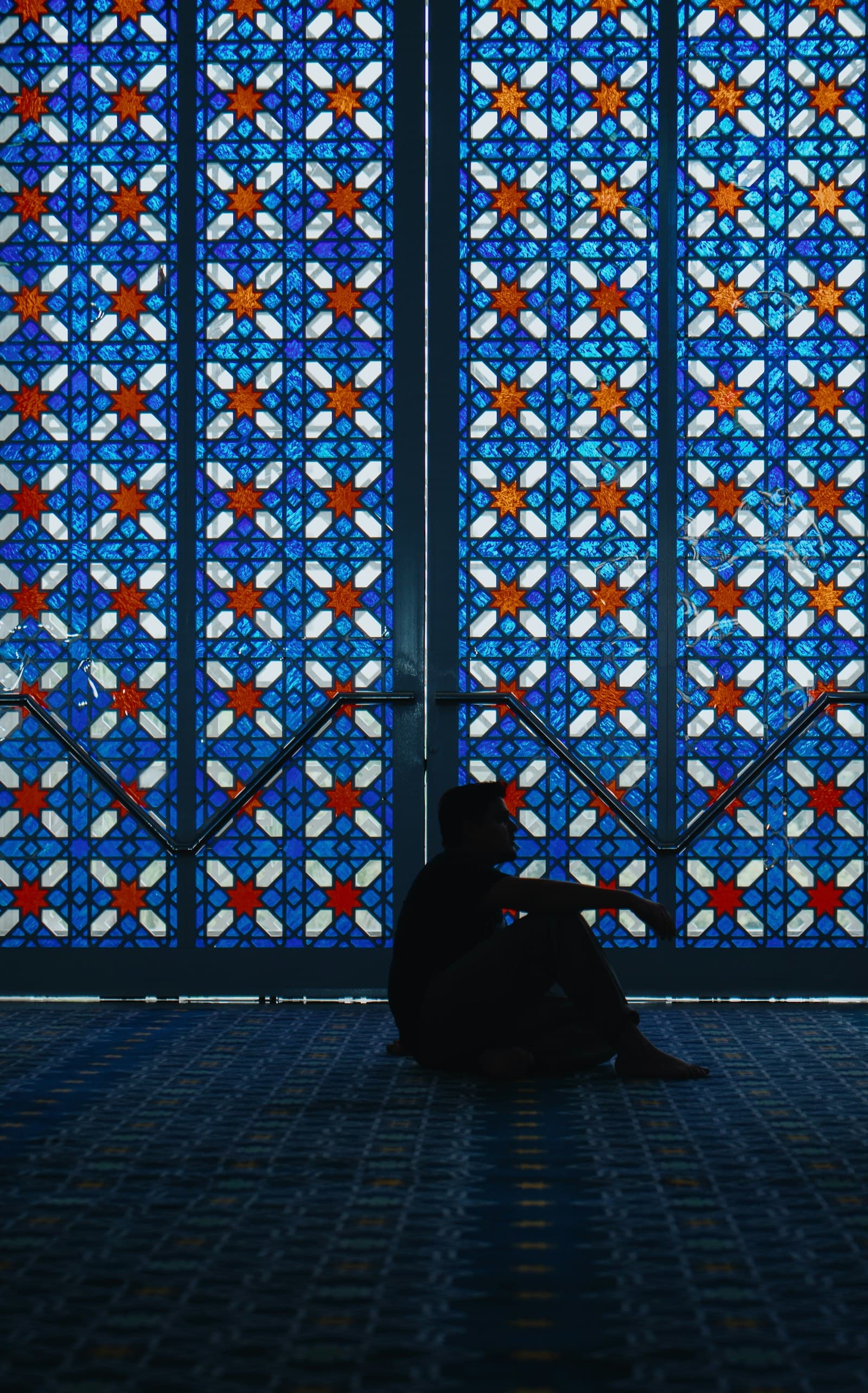 A person sitting in front of a stained glass window